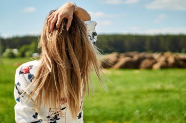 Arkadaki kadın saçlarına arkadan dokunuyor..