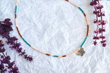 El yapımı boncuk, hobi olarak boncuklama. Çeşitli çiçek ve bitkilerin arka planında kendi ellerinizle yapılmış süslemeler..