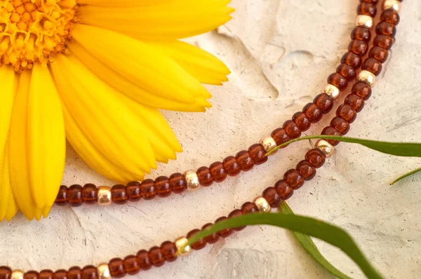 Handmade beadwork, beading as a hobby. Decorations made with your own hands on the background of various flowers and plants.