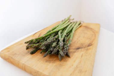 Ahşap masada yalıtılmış yeşil kuşkonmaz