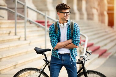 gözlük ve üniversite, önüne bisikletiyle üzerinde bisiklet duran genç öğrenci kameraya ile güven ve büyük gülümseme ile seyir silah katlanmış