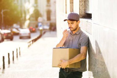 Senin nakliye işte. sokakta bir yerde onun kollarında parsel olması onun teslim formu, notlar odaklı kurye