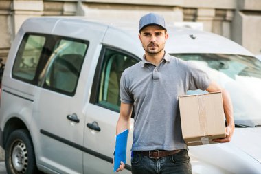 Senin nakliye işte. arabasını, önünde sokakta onun karton kutu ile kap ayakta ile gri tişörtlü teslimat adam kameraya gülümseyen