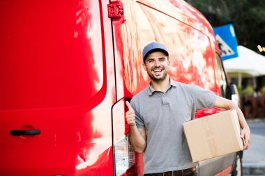 Senin nakliye işte. arabasını, paketin istemciye, dışarıda sokakta, vermeye hazır arkasında onun karton kutu ile kap ayakta ile gri tişörtlü teslimat adam güven ve ok işareti gösteren