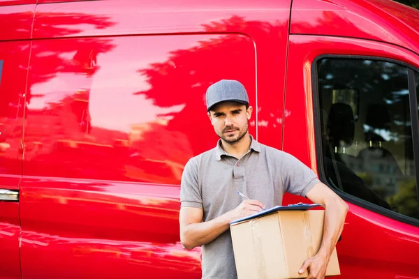 Senin nakliye işte. Onun karton ile kap ayakta ile gri tişörtlü adam genç teslimat kutusu formunu teslim, arabasının önünde sokakta istemcinin, dışarıda tanışmaya hazır için