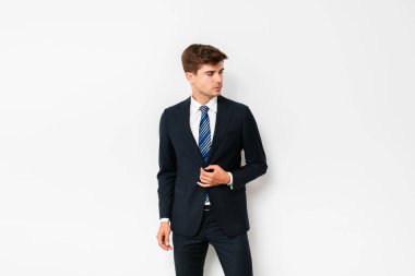 poz ve yan, beyaz arka plan üzerinde duran isteyen zarif yakışıklı erkek takım elbise,