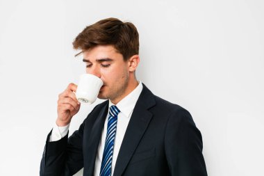takım elbiseli, beyaz arka plan üzerinde bir kahve içme, zor bir gece sonra kurtarma veya yeni bir gün başlatma office işadamı, zarif adam