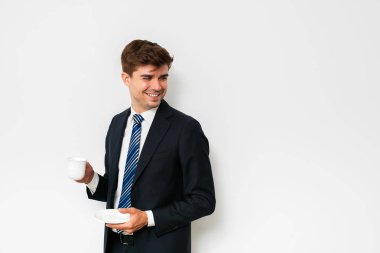 takım elbiseli, beyaz arka plan üzerinde bir kahve içme, zor bir gece sonra kurtarma veya yeni bir gün başlatma office işadamı, şık erkek gülümseyen