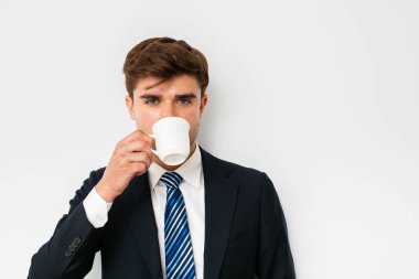 takım elbiseli, beyaz arka plan üzerinde bir kahve içme, zor bir gece sonra kurtarma veya yeni bir gün başlatma office işadamı, zarif adam