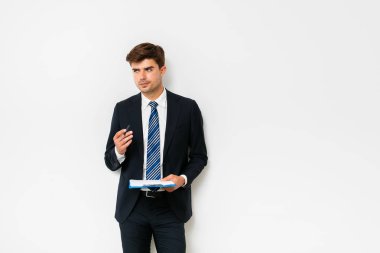 Beyaz arka plan üzerinde duran ve Pano elinde bir çözüm hakkında düşünme elbiseli şık adam