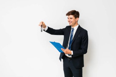 Yeni araba için zaman. zarif satıcı, bir anlaşma kapanış ve beyaz araba anahtarları ve Pano ile sözleşme ile ayakta yeni bir müşteri için bir araba satış