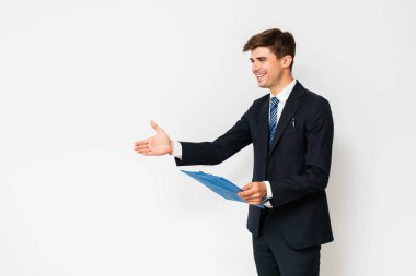 bir anlaşma. Yakışıklı şık erkek takım elbise, işadamı veya satıcı, sözleşme elinde bir iş sonuçlandırmak için elini uzatır