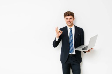 kendine güvenen zarif işadamı ya da dizüstü bilgisayar ile beyaz arka plan üzerinde duran satıcısı,