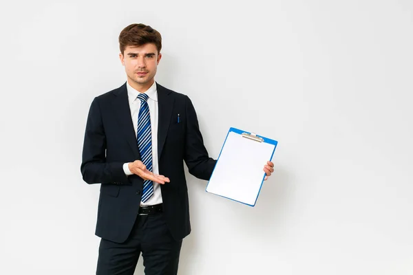 Confident Businessman Suit Showing His Clipboard Camera Smiling Standing White — Stock Photo, Image