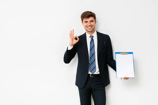 Hombre Negocios Confiado Traje Mostrando Portapapeles Cámara Sonriendo Pie Sobre —  Fotos de Stock