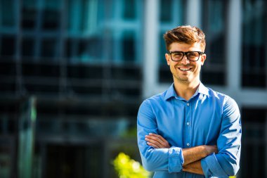 mavi gömleğin içinde kendine güvenen bir ofis bina önünde duran başarılı antrepreneur portresi