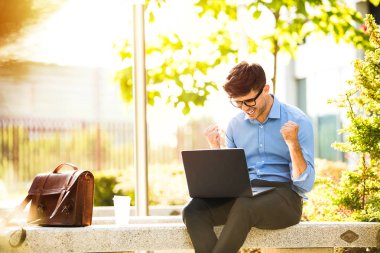Uzaktan çalışma. Genç yakışıklı antrepreneur çalışmaktan dışında dizüstü bilgisayar önünde ile güneşli güzel gününde