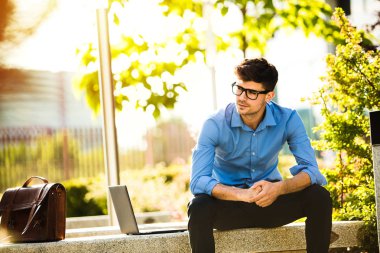 Uzaktan çalışma. Genç yakışıklı antrepreneur çalışmaktan dışında dizüstü bilgisayar önünde ile güneşli güzel gününde