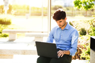 Uzaktan çalışma. Genç yakışıklı antrepreneur çalışmaktan dışında dizüstü bilgisayar önünde ile güneşli güzel gününde