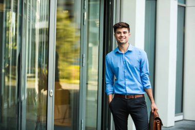 kendinden emin ve başarılı antrepreneur, office adam veya deri çanta ve zarif kıyafeti bir ofis binası önünde duran kurumsal adam