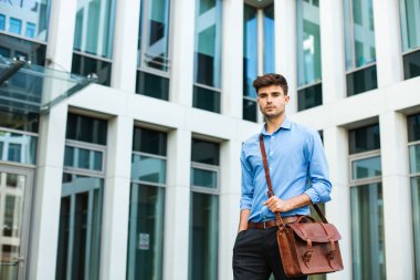 kendinden emin ve başarılı antrepreneur, office adam veya deri çanta ve zarif kıyafeti bir ofis binası önünde duran kurumsal adam