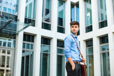 kendinden emin ve başarılı antrepreneur, office adam veya deri çanta ve zarif kıyafeti bir ofis binası önünde duran kurumsal adam