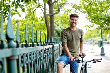 ayakta dışında onun motor, bicyclet ile bir gezintiye hazır yanındaki yakışıklı genç