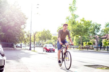 Genç adam onun dışında şehir merkezinde Bisiklete binmek