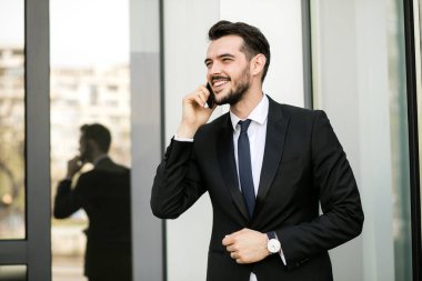 zarif yakışıklı biriyle cep telefonu üzerinde güzel konuşmayı takım elbiseli clouse veya dışında bir ofis binasının yanında karısı ile