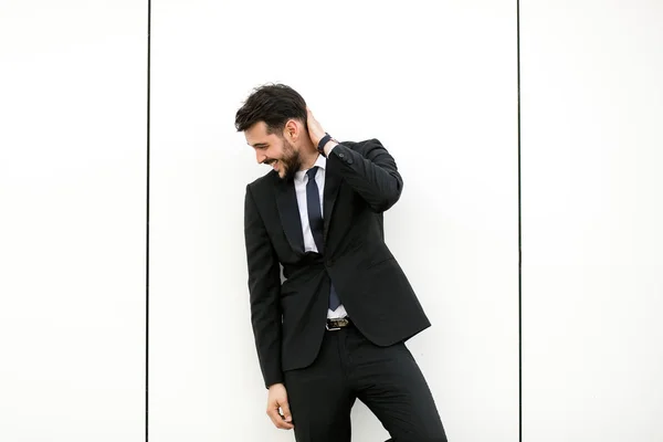スーツ ビジネスマン プレゼンター 空き領域 Aroiund と対話する白い壁に立って何かを示す彼のエレガントな男 — ストック写真