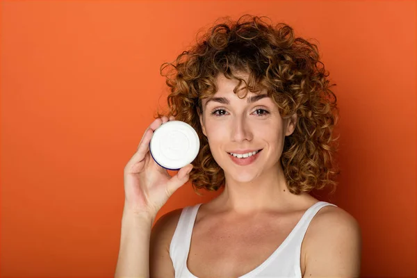 Jeune Femme Bouclée Tenant Une Petite Boîte Crème Peau Sur — Photo