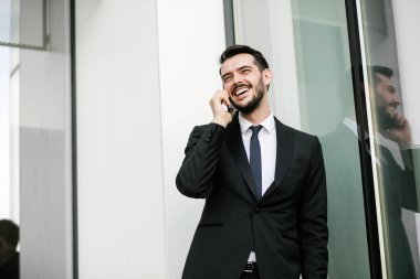 zarif yakışıklı biriyle cep telefonu üzerinde güzel konuşmayı takım elbiseli clouse veya dışında bir ofis binasının yanında karısı ile