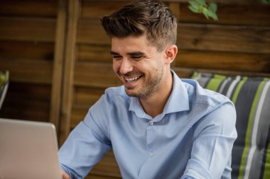 Uzaktan çalışma. yakışıklı delikanlı, blogger veya teras dışında laptop ile uzaktan çalışma