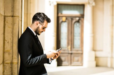 şık şık adam dışında saati zaman kontrol büyük Supervisor builing eski bir sütun karşı ayakta, başarılı iş adamı,