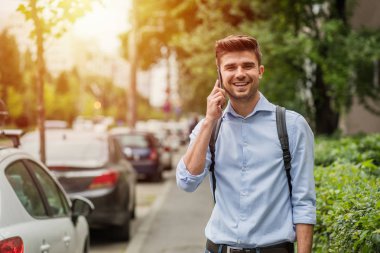 şehirde yaşayan. Sırt çantası cep telefonu konuşurken sokakta ile akıllı casual adam