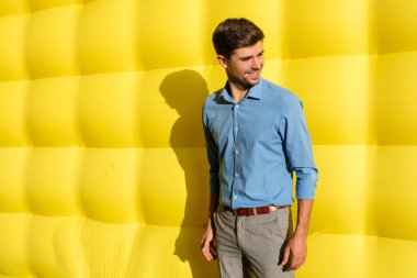 sarı bir arka plan üzerinde duran zarif zeki adam