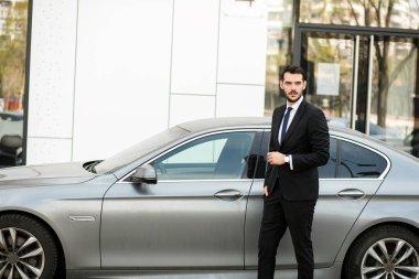 zarif ve başarılı bir adam ayakta dışında pahalı arabası sürüş için hazır ile