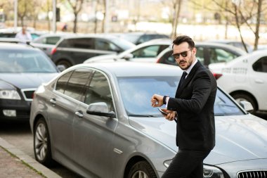 saatini kontrol bir toplantı, onun lüks sedan dan dışarı sadece steping olacak zarif ve başarılı işadamı