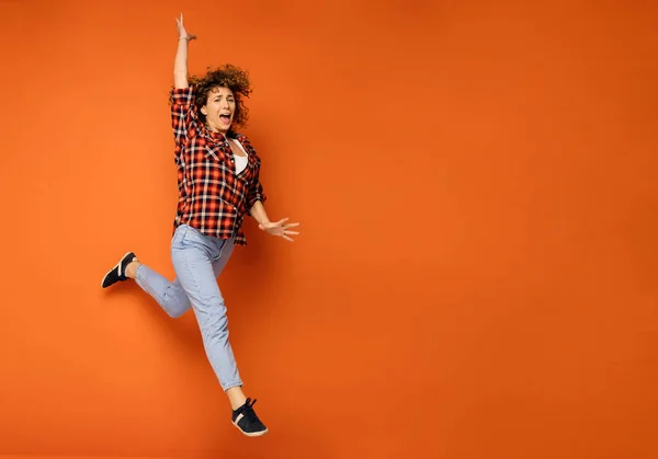 Blij Krullend Vrouw Een Geruite Shirt Spijkerbroek Permanent Een Oranje — Stockfoto