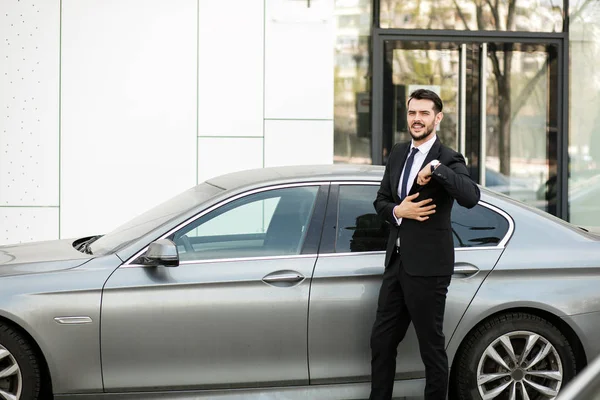zarif ve başarılı bir adam ayakta dışında pahalı arabası sürüş için hazır ile