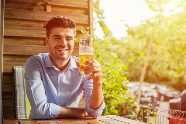 İşten sonra rahatla. Ofis iş sonra bir bira dışında ile terrace adlı genç adam, rahatlatıcı akıllı