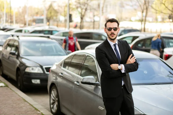 başarılı şık erkek güneş gözlüğü ve şık takım elbise onun limuzin önünde duran ve güven ile seyir