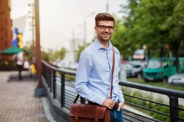 office sonra eve gidiyorum. yakışıklı zeki casual adam gözlük ve deri çanta dışında işten sonra yürüyüş