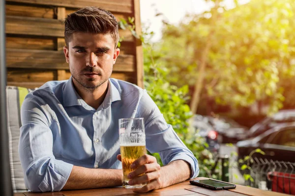 İşten sonra rahatla. Ofis iş sonra bir bira dışında ile terrace adlı genç adam, rahatlatıcı akıllı