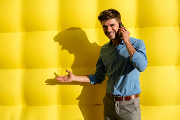 Elegantní Příležitostné Chytráku Mobil Prezentovat Nabídku Jeho Straně Stojící Žlutém — Stock fotografie