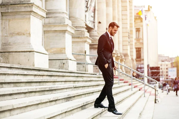 busy elegant stylish man, successful businessman, walking on stairs of important building, university or law court going to an important meeting with confidence