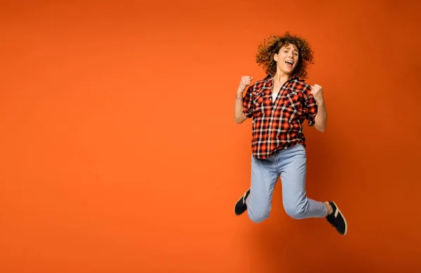 Blij Krullend Vrouw Een Geruite Shirt Spijkerbroek Permanent Een Oranje — Stockfoto