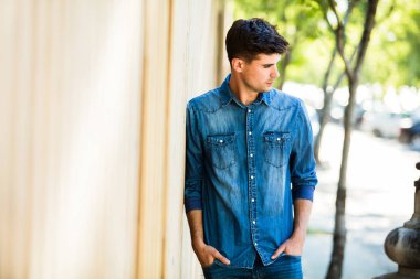 kot kıyafeti bir şehrin sokakta bir ahşap duvar yanındaki genç adam