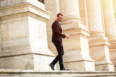 önemli bir toplantı için güven ile gidiş önemli binası, üniversite veya Hukuk Mahkemesi merdivenlerde yürüyen meşgul zarif şık adam, başarılı bir iş adamı,