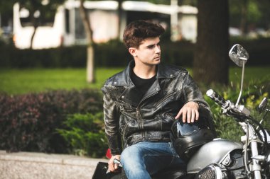 Genç ve güzel. birini bekliyor ve bir yere bir şehir merkezinde rahatlatıcı onun motosiklet üzerinde oturan yakışıklı adam